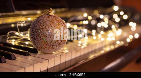 Christmas Piano music, Xmas decoration and lights bokeh background. Holiday celebration concert, party festive songs, Stock Photo