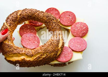 Traditional Turkish Crunchy Bagel,Simit with Sliced Sausage Cheese and Egg on white surface Stock Photo