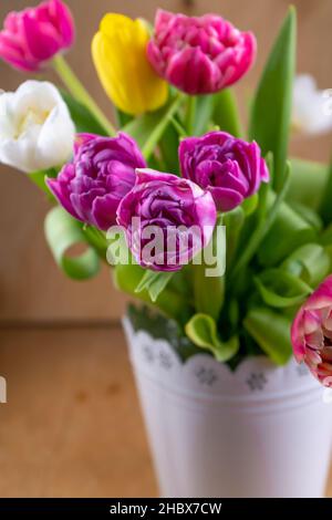 Mix of spring tulips flowers. Bouquet in a vase. Multi-colored spring flower. Gift. Red, pink, white and yellow. Background with flowers tulips close-up different colors. Stock Photo