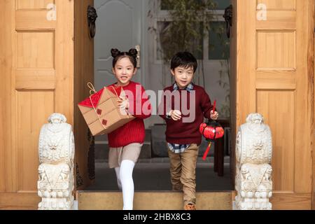 Brother and sister holding lanterns and gift boxes Stock Photo