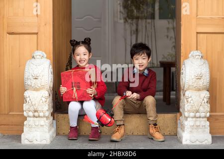 Brother and sister holding lanterns and gift boxes Stock Photo