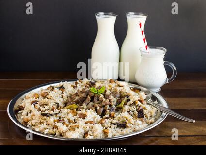 Traditional Turkish Sacrifice Festival Food braised meat Kavurma and pilaff in the large metal tray with big spoon and  traditional drink buttermilk Stock Photo