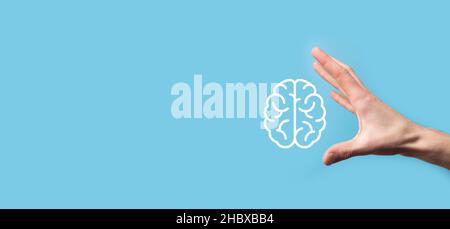 Male hand holding brain icon on blue background. Artificial intelligence Machine Learning Business Internet Technology Concept.Banner with copy space. Stock Photo