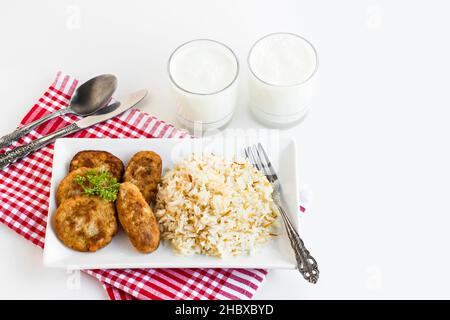 Traditional Turkish Vermicelli Rice or pilaff on the long plate with meatball.Served with cold,foamy buttermilk drink.The Sacrifice Feast Concept Stock Photo