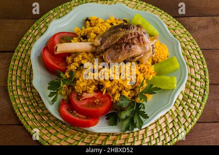 Traditional Saffron Arabian Rice,Pilaff with lamb shank on the wooden table.The Sacrifice Feast Concept Stock Photo