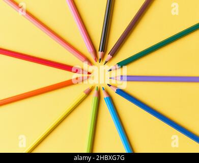 wooden color pencils on yellow paper background, top view Stock Photo