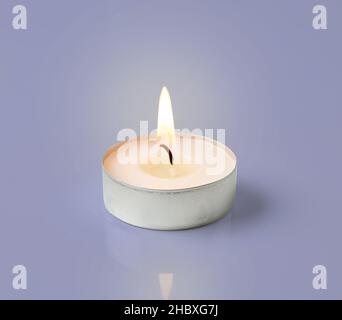 burning tea light candle isolated on violet background Stock Photo