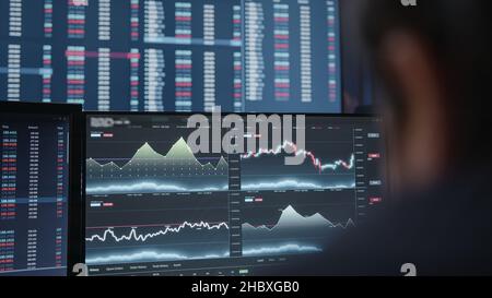 Extreme close-up young adult man, crypto stock chart monitor background he is analyzing crypto coin Stock Photo