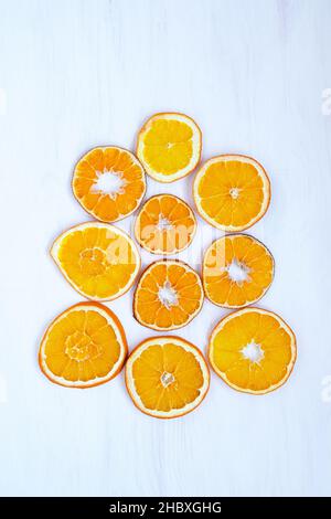Sliced dried orange on white wooden background, christmas decorations, citrus fruits, orange vertical photo Stock Photo