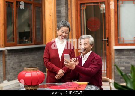 Elderly couple using smartphones in the new year Stock Photo
