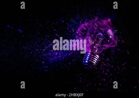 explosion of an electric light bulb on black. purple and blue light. Stock Photo