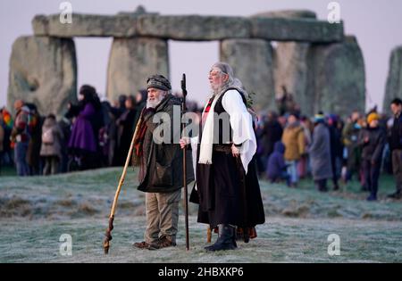 People take part in the winter solstice celebrations during sunrise at the Stonehenge prehistoric monument on Salisbury Plain in Wiltshire. Picture date: Wednesday December 22, 2021. Stock Photo