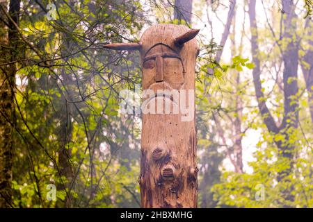 The image of the Slavic deity Veles carved from a tree trunk on a neo-Pagan temple in the forest. Kaluzhskiy region, Russia. Veles - the god of cattle Stock Photo