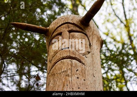 The image of the Slavic deity Veles carved from a tree trunk on a neo-Pagan temple in the forest. Kaluzhskiy region, Russia. Veles - the god of cattle Stock Photo