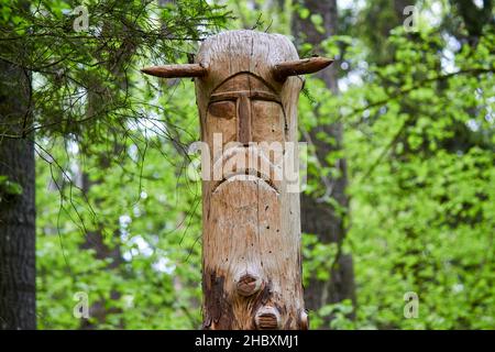 The image of the Slavic deity Veles carved from a tree trunk on a neo-Pagan temple in the forest. Kaluzhskiy region, Russia. Veles - the god of cattle Stock Photo