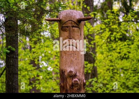 The image of the Slavic deity Veles carved from a tree trunk on a neo-Pagan temple in the forest. Kaluzhskiy region, Russia. Veles - the god of cattle Stock Photo