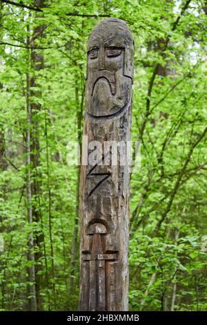 The image of the Slavic deity Veles carved from a tree trunk on a neo-Pagan temple in the forest. Kaluzhskiy region, Russia. Veles - the god of cattle Stock Photo