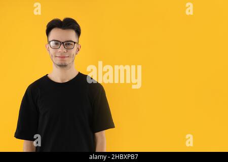 Young man in glasses on yellow background Stock Photo