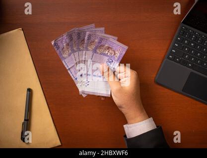 Businessman or CEO or Politician hands holding bribe money on an office desk. Venality, bribe, corruption concept. Stock Photo