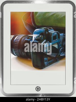 Tablet with camera on screen showing  camera dslr and bag. Light flare in the background. Room to write. Stock Image. Stock Photo
