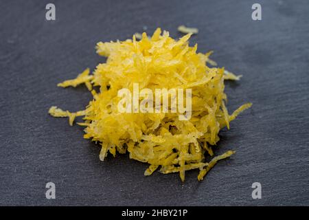 lemon zest isolated on black stone tile texture Stock Photo