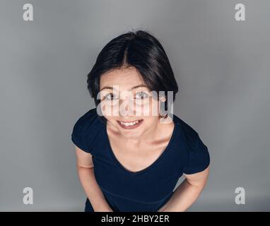 Portrait of cheerful dark-haired woman. Top view. Emotions of joy and happiness. Snow-white smile. Stock Photo
