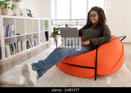 Portrait of smiling black woman using laptop at home Stock Photo