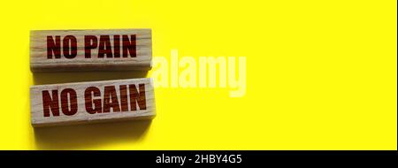 No Pain No Gain message written with wooden blocks on yellow. Business success concept. Stock Photo