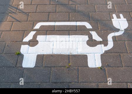 white car sign for parking and charging of cars painted on the street Stock Photo
