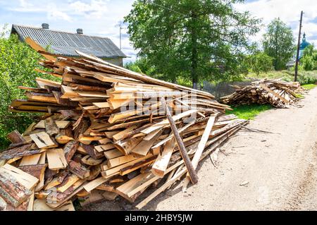Chopped and stacked up dry firewood at the countryside. Stock pile of timber, chopped down trees at the village Stock Photo