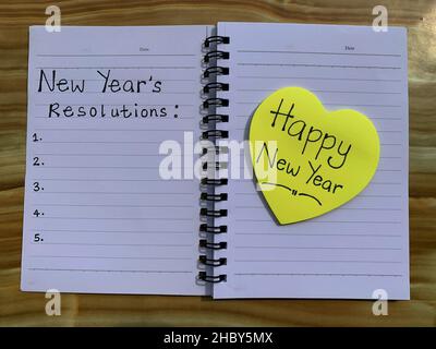 Beautiful wishes on sticky notes with new year resolutions note written on a note pad. Stock Photo