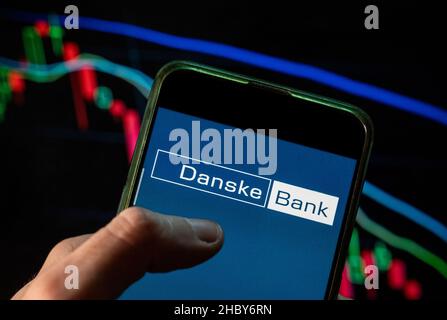 China. 09th Dec, 2021. In this photo illustration the Danish Danske Bank logo seen displayed on a smartphone with an economic stock exchange index graph in the background. (Photo by Budrul Chukrut/SOPA Images/Sipa USA) Credit: Sipa USA/Alamy Live News Stock Photo