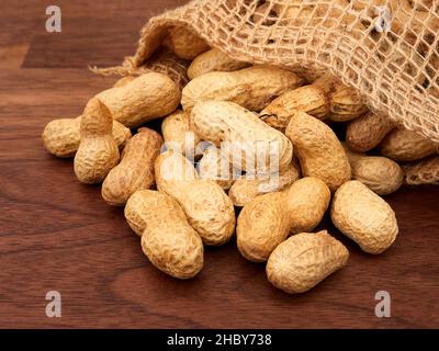 Raw peanuts in a bag, uncooked, not salted. on a walnut table Stock Photo