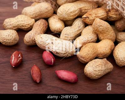 Raw peanuts in a bag, uncooked, not salted. on a walnut table Stock Photo