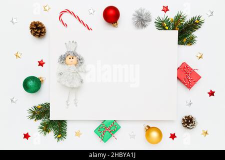Christmas, New Year holiday layout with copy space. Small princess on blank white paper, natural fir tree branches and pinecones, gifts, decorations, Stock Photo