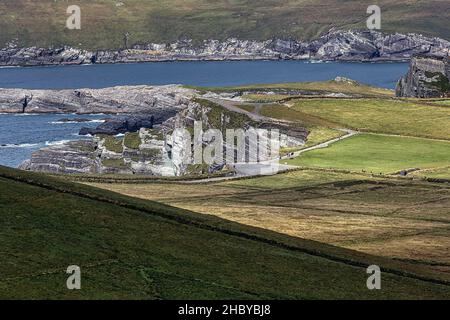 View of meadows and cliffs from Coomanaspig Pass, Skellig Ring panoramic road, Portmagee, Iveragh Peninsula, Kerry, Ireland Stock Photo