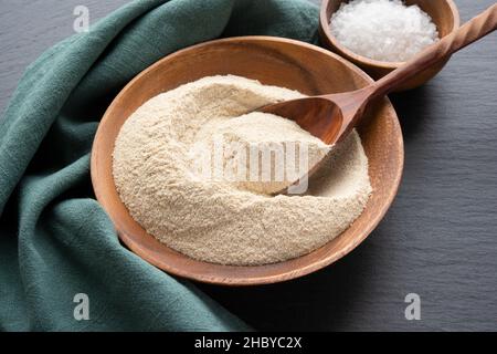 Amaranth flour with a spoon in wooden bowl on black slate background high angle view Stock Photo