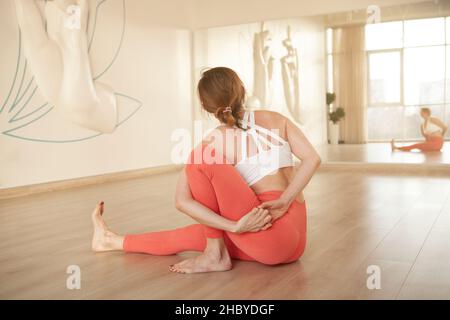 Rear view shot of a sportswoman stretching her body while practicing yoga at the studio Stock Photo