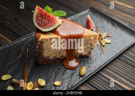 Cheesecake on a dark stone, wooden background, with mint and figs Stock Photo