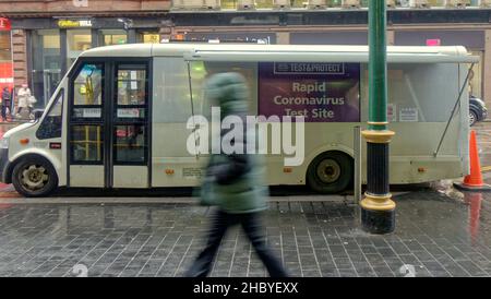 Glasgow, Scotland, UK  22nd  December, 2021. UK  Weather: Wet covid Christmas streets saw locals struggle in the rain with signs of Christmas all around them Central railway station saw covid testers in forve as a tarheted venue fopr infornation..Credit  Gerard Ferry/Alamy Live News Stock Photo