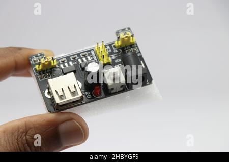 Breadboard power supply module held in hand isolated on white background Stock Photo