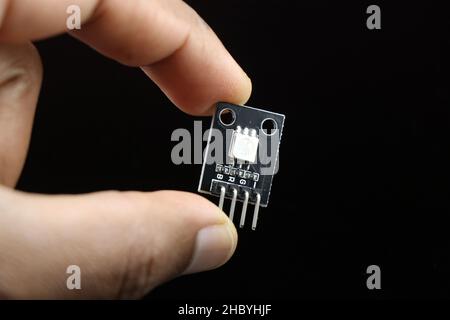 SMD RGB LED module for programmable microcontroller boards held in hand isolated on black Stock Photo