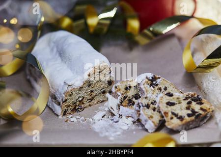 Classic Christmas stollen, Christstollen - seasonal yeast bread. Christmas tradition with bokeh background. Festive background. Stock Photo