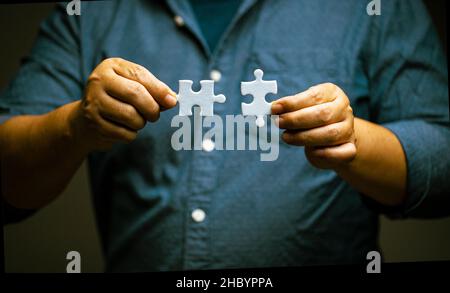 man hand connecting jigsaw puzzle. Business solutions and success concept. Network, strategy and teamwork. Stock Photo
