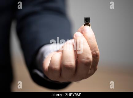 Legal security, pinhole camera, privacy of Personal Information , businessman holding pinhole camera in hand. Stock Photo