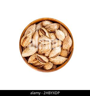 Top view of roasted brown almond nuts in cracked shell in wooden bowl isolated on white background. Stock Photo