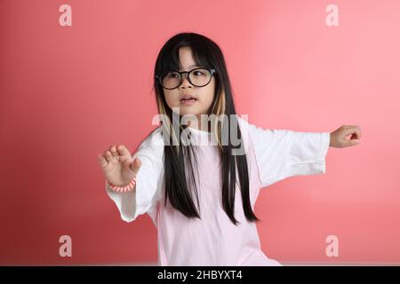 The young Asian girl portrait on the pink background. Stock Photo