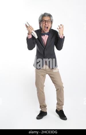 The senior Asian teacher standing on the white background. Stock Photo