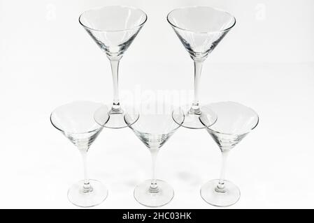 Empty martini cocktail glasses stand on top of each other on white background Stock Photo