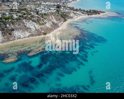 Aerial view of white rocky cliffs at Scala dei Turchi, Sicily, Italy, with turquoise clear water. Drone shot of the limestone rock formation and beach Stock Photo